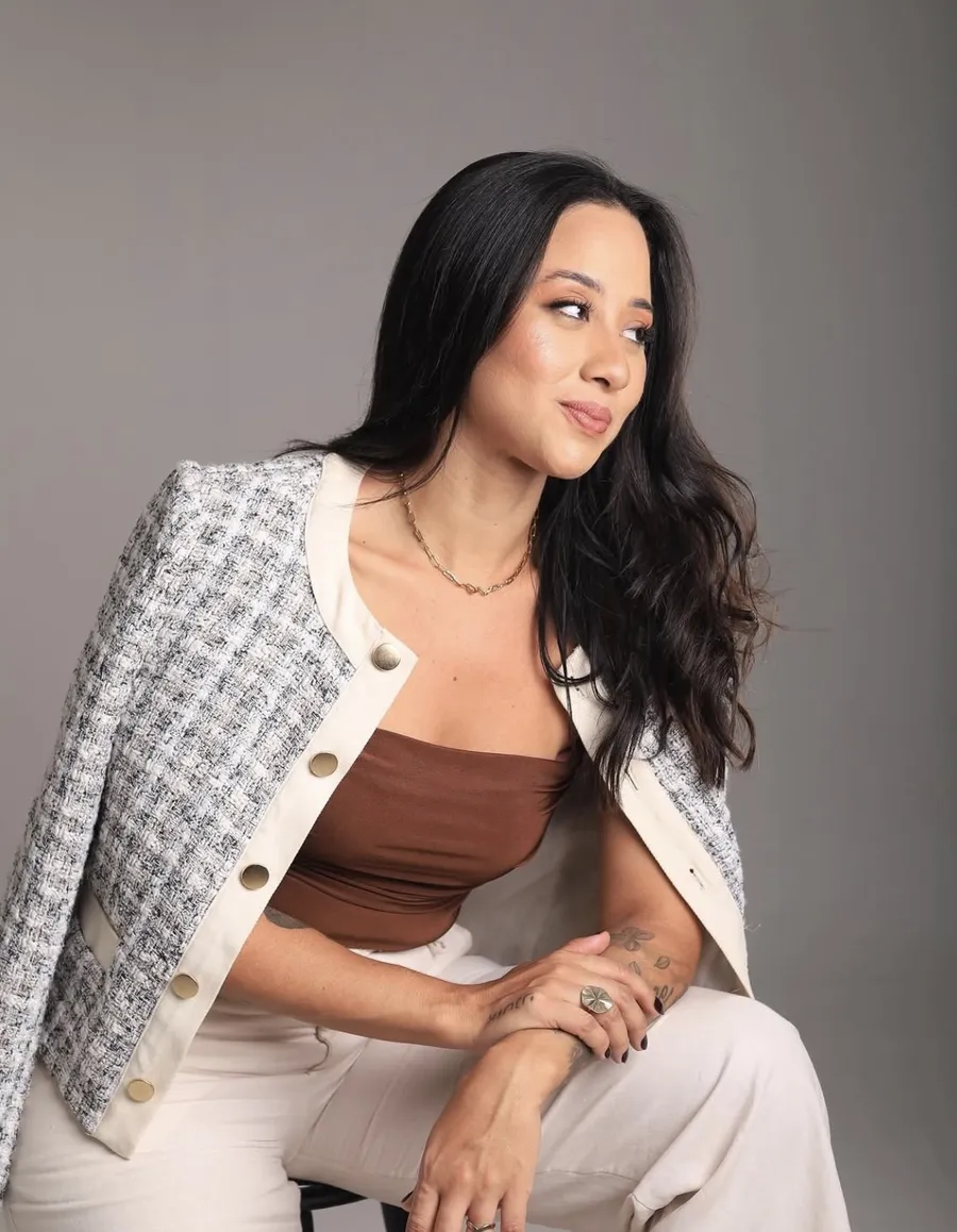 Laryssa Galvão, psicóloga, sentada com blazer de tweed